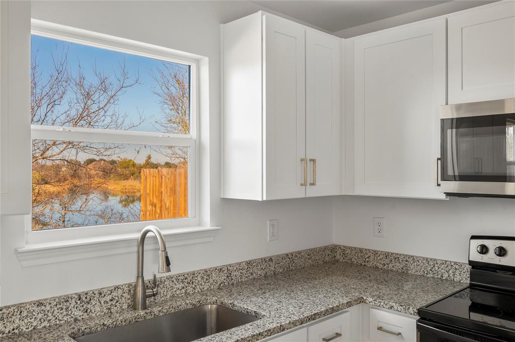 437 Whitney Court Rio Vista, TX 76093 - Photo 9 of 21 a kitchen with stainless steel appliances granite countertop a sink and a white cabinets