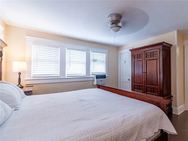 a bedroom with a bed large mirror and a lamp