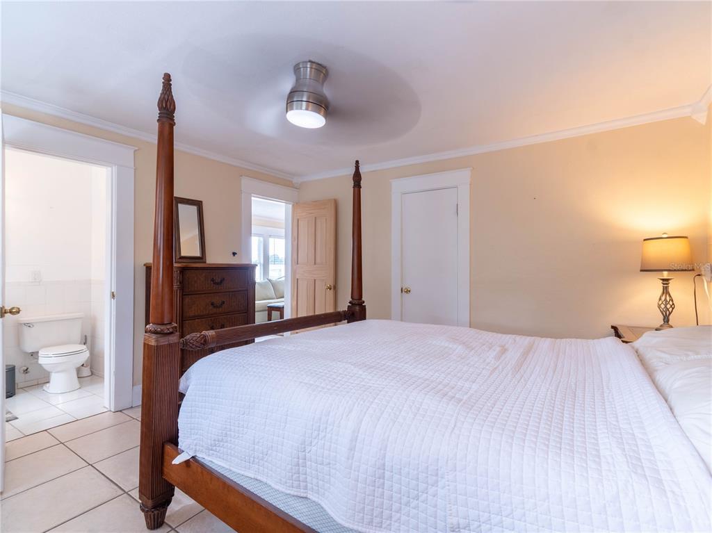 103 East Mohawk Avenue, Unit A Tampa, FL 33604 - Photo 15 of 19 a bedroom with a bed large mirror and a lamp