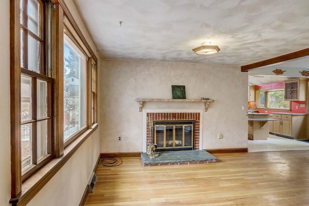 24 Governor Fuller Road Billerica, MA 01821 - Photo 6 of 25 a view of an empty room with wooden floor fireplace and a window