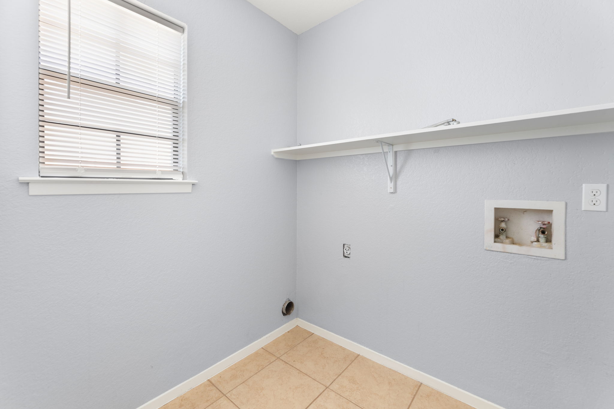 3802 Foust Trail, Unit A Georgetown, TX 78628 - Photo 13 of 34 A well-appointed utility room features convenient shelving and durable tiled flooring.