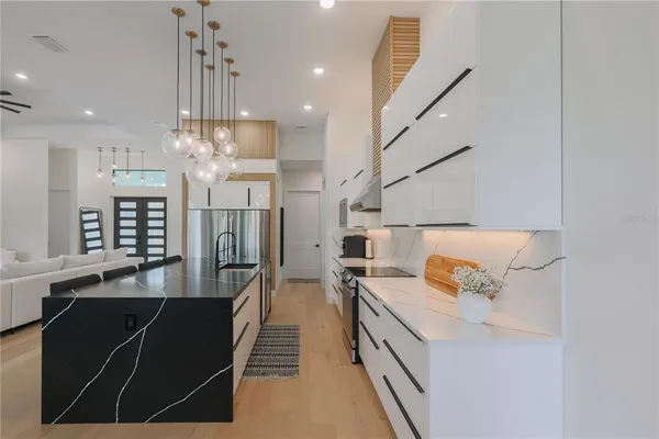 a kitchen with stainless steel appliances kitchen island granite countertop a sink and a refrigerator