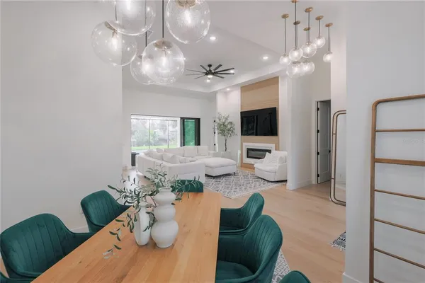 a living room with furniture a chandelier and a fireplace