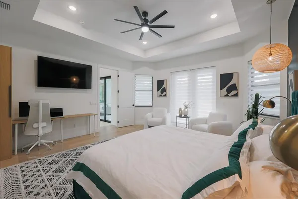 a spacious bedroom with a bed a flat screen tv and couches