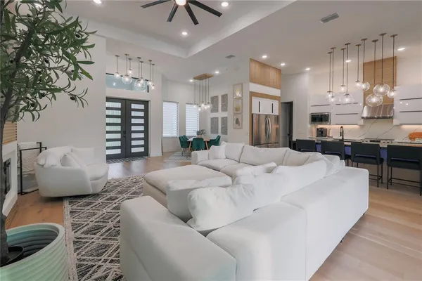 a large white room with stainless steel appliances kitchen island granite countertop a couch and a view of kitchen