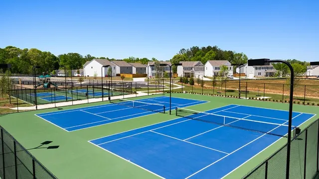 a view of a tennis ground with large trees