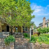 a front view of a house with plants and trees