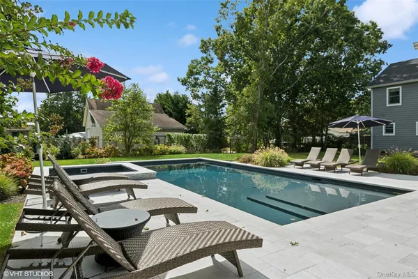 a view of a swimming pool with chairs and table