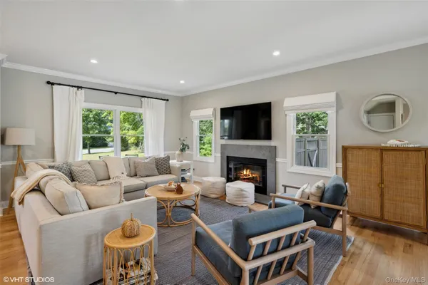 a living room with furniture a fireplace and a large window