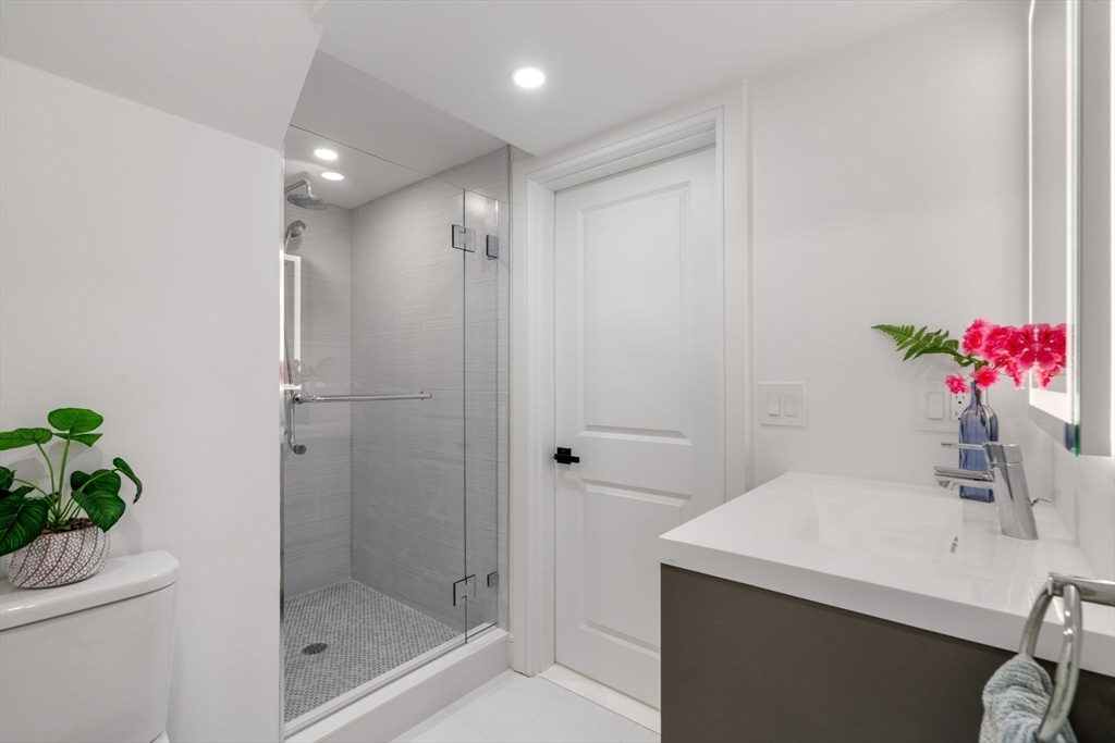 11 Ashford Road Newton, MA 02459 - Photo 28 of 41 a bathroom with a shower sink vanity and mirror