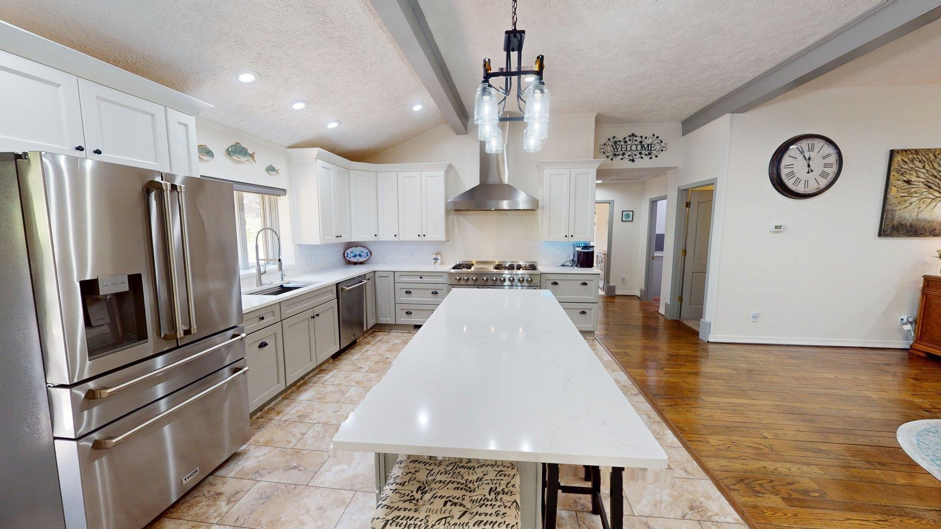 650 Caney Hollow Road Counce, TN 38326 - Photo 7 of 40 a large kitchen with stainless steel appliances kitchen island granite countertop a refrigerator a stove a sink dishwasher and a dining table with wooden floor