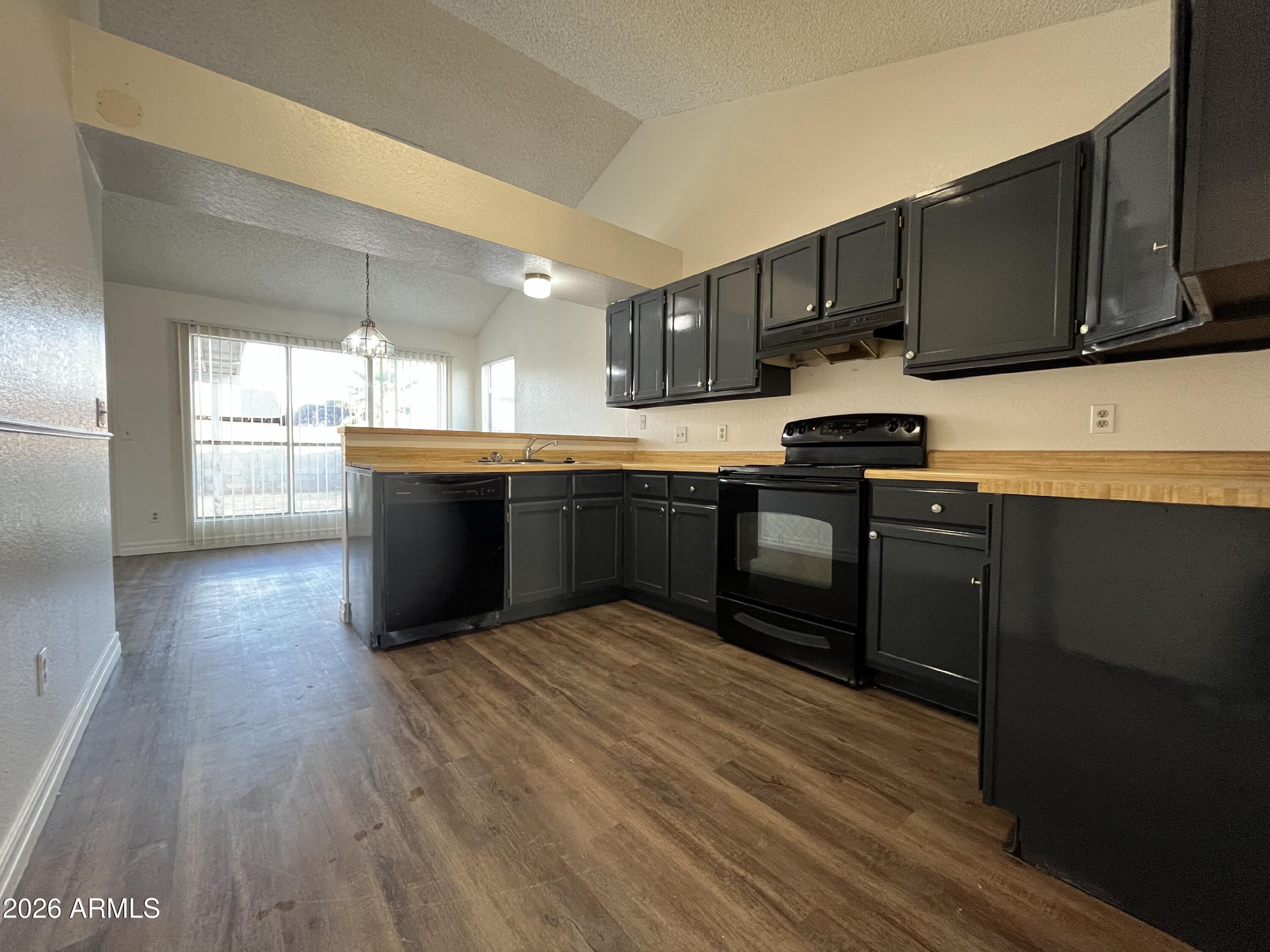 7119 West McLellan Road Glendale, AZ 85303 - Photo 13 of 14 a kitchen with stainless steel appliances granite countertop a sink stove and wooden floor