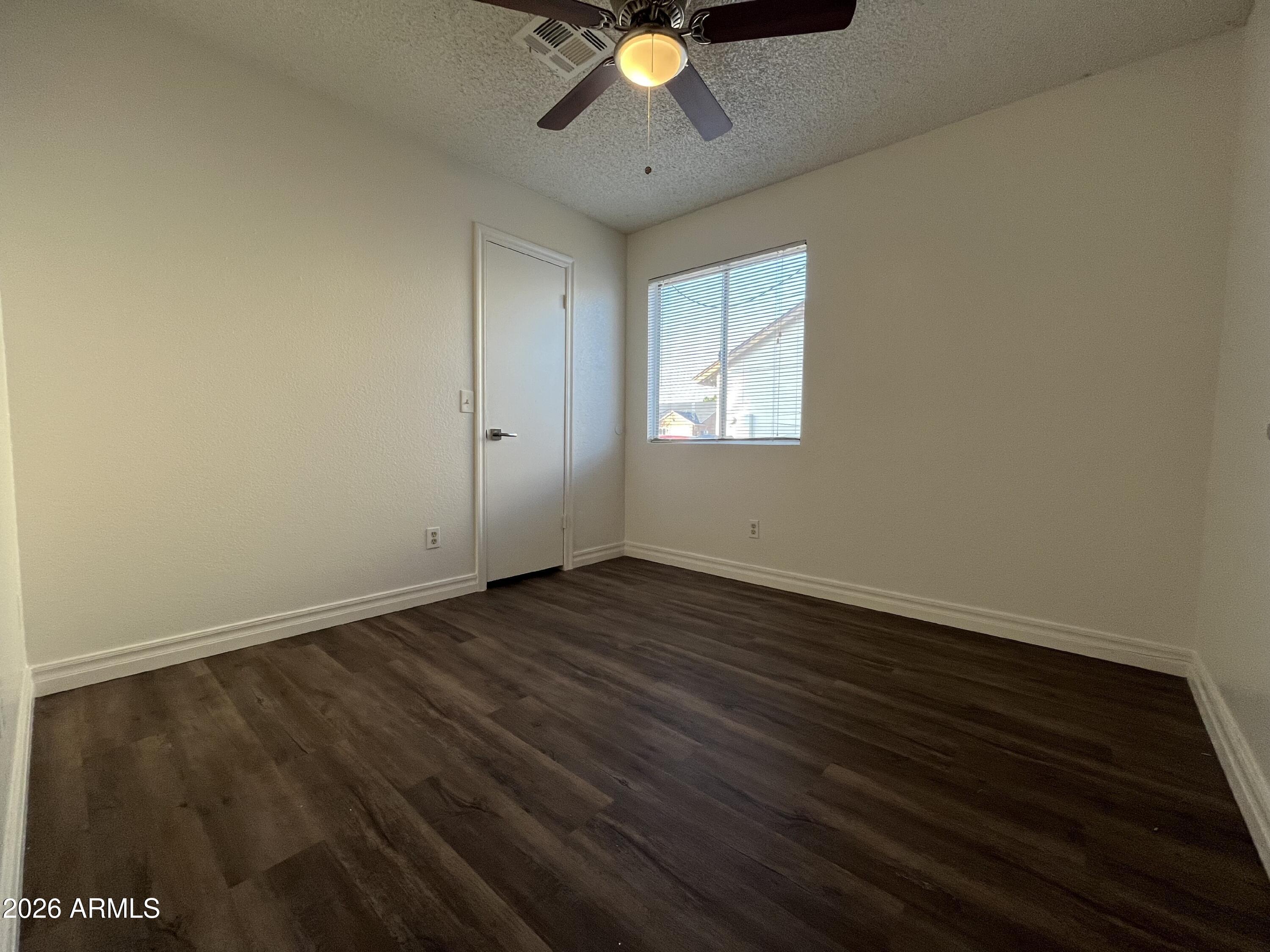 7119 West McLellan Road Glendale, AZ 85303 - Photo 4 of 14 wooden floor in an empty room with a window