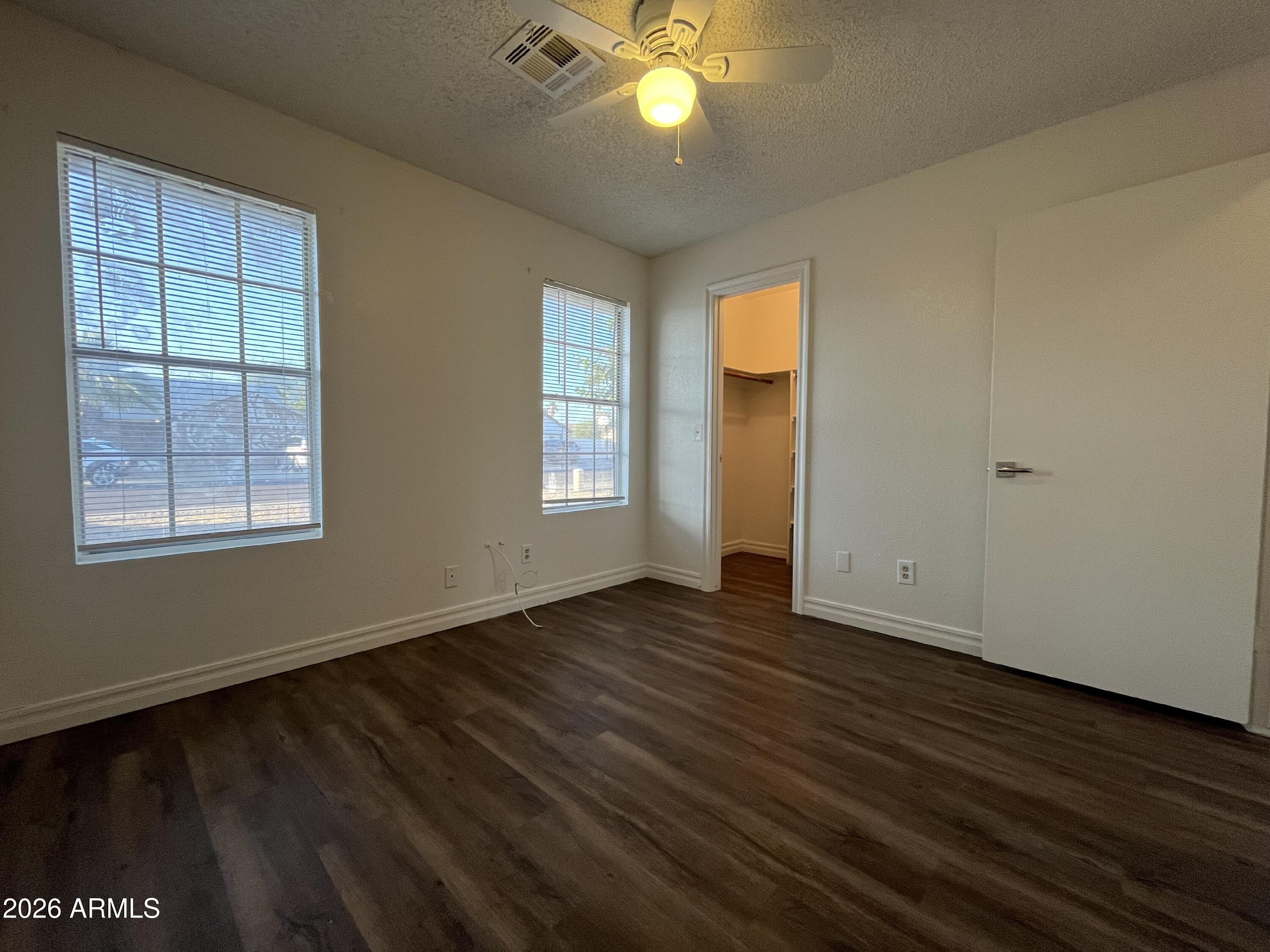 7119 West McLellan Road Glendale, AZ 85303 - Photo 6 of 14 a view of an empty room with wooden floor and a window