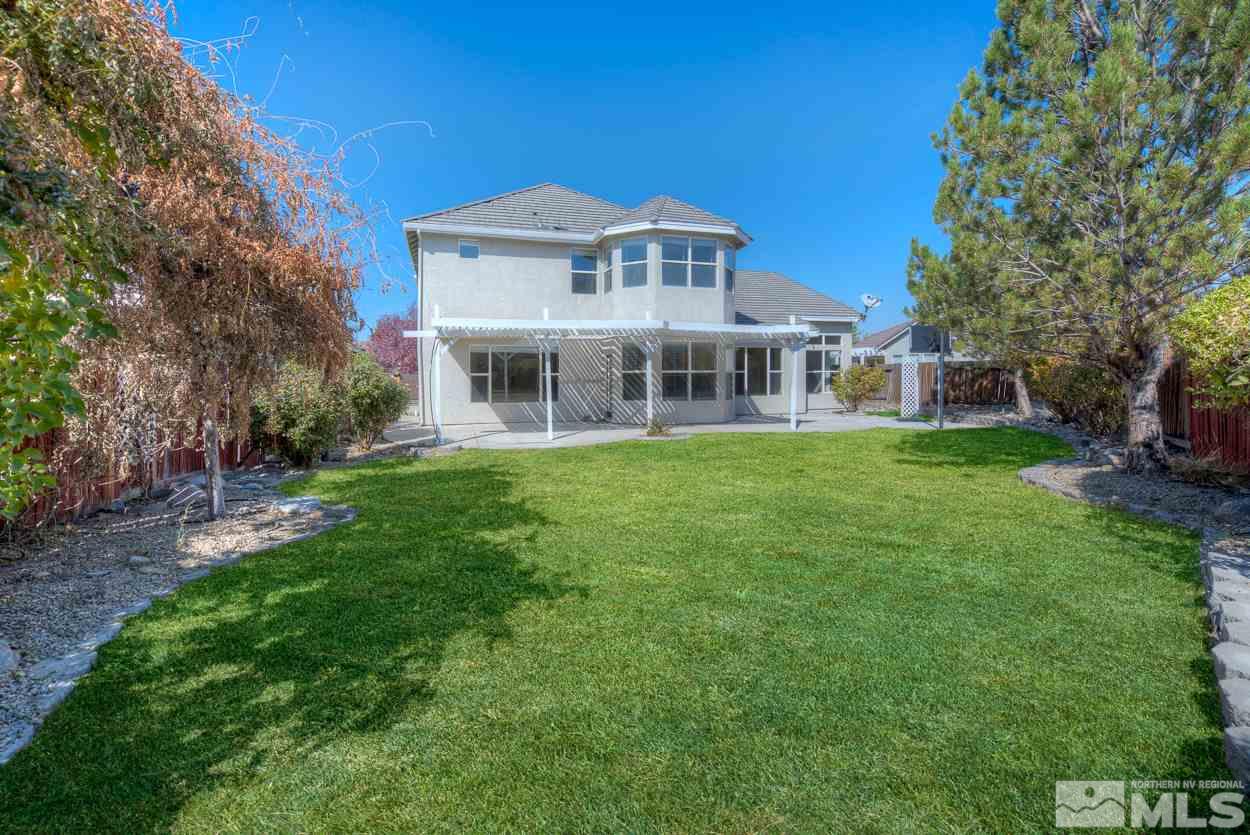 1580 Sutterbrook Way Reno, NV 89521 - Photo 23 of 25 a front view of a house with a garden and trees