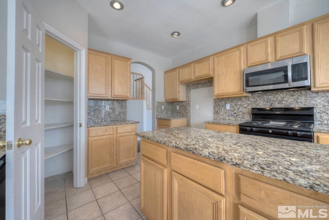 1580 Sutterbrook Way Reno, NV 89521 - Photo 7 of 25 a kitchen with stainless steel appliances granite countertop a stove a sink and a microwave