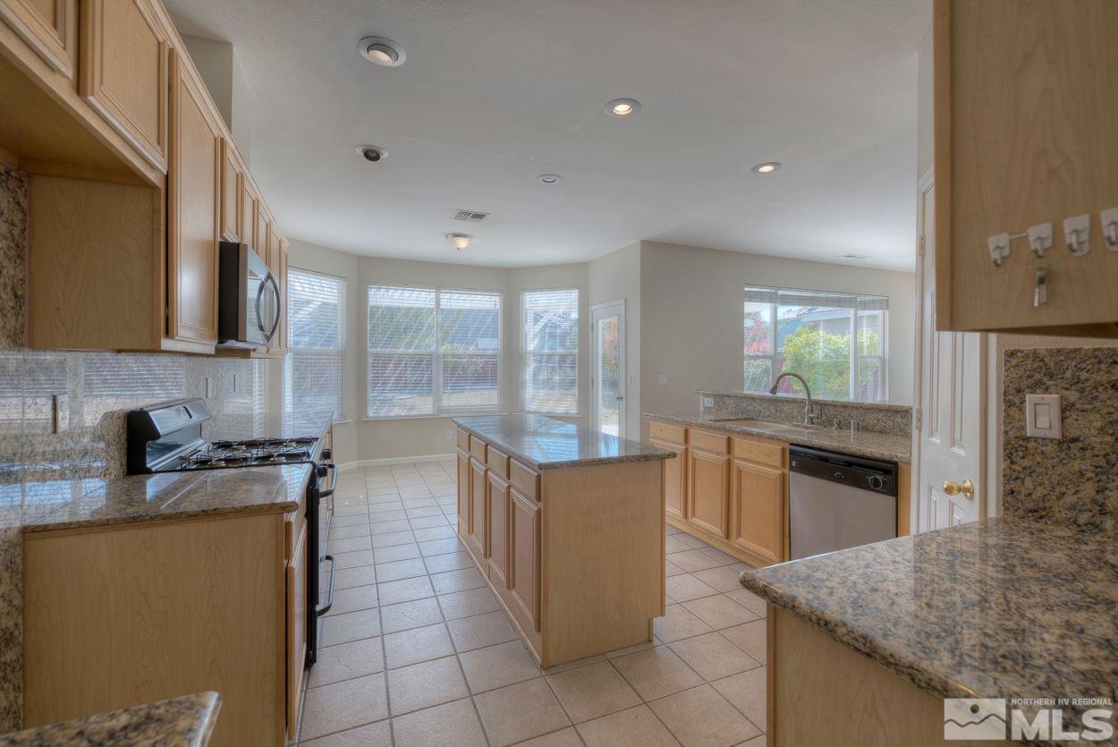 1580 Sutterbrook Way Reno, NV 89521 - Photo 8 of 25 a kitchen with granite countertop a stove a sink and a microwave