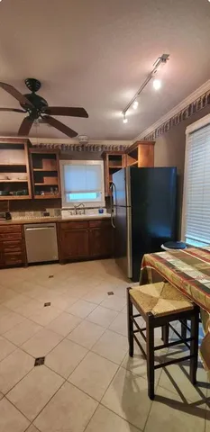 a kitchen with stainless steel appliances kitchen island granite countertop a refrigerator and a stove top oven