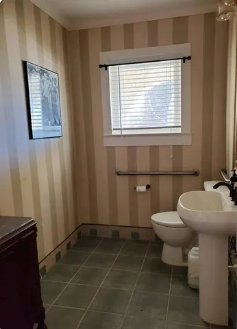a bathroom with a toilet a sink and a window