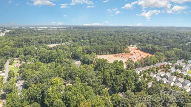 an aerial view of residential houses with outdoor space and trees