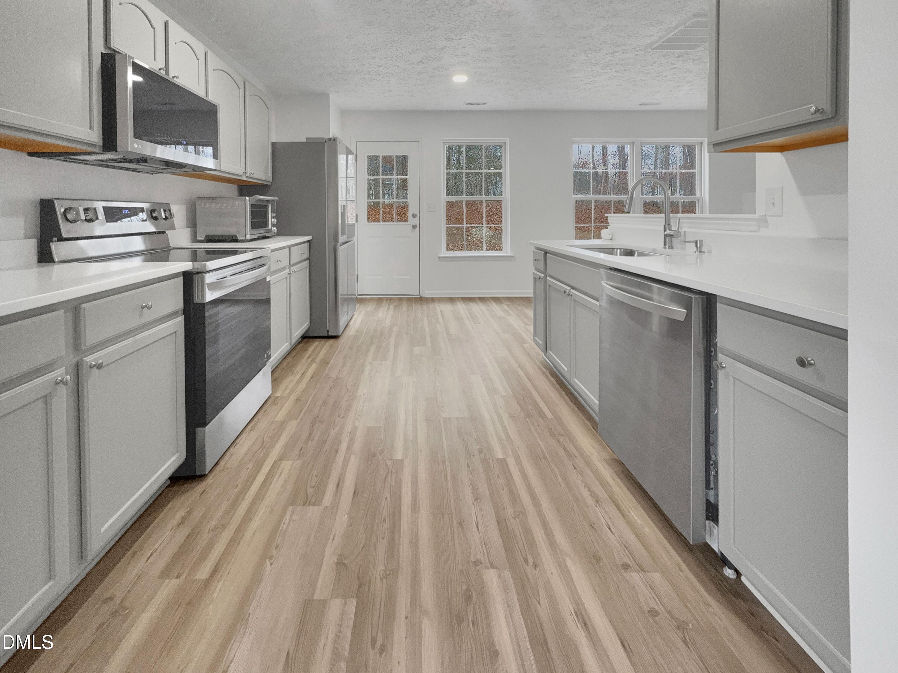 2816 Smoke Place Raleigh, NC 27610 - Photo 5 of 21 a kitchen with a sink wooden floor and stainless steel appliances