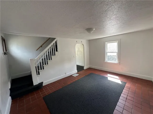 a room with granite countertop white cabinets and wooden floor