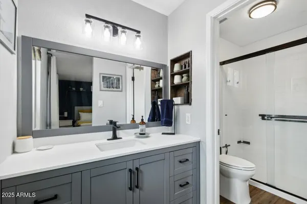 a bathroom with a double vanity sink toilet mirror and shower