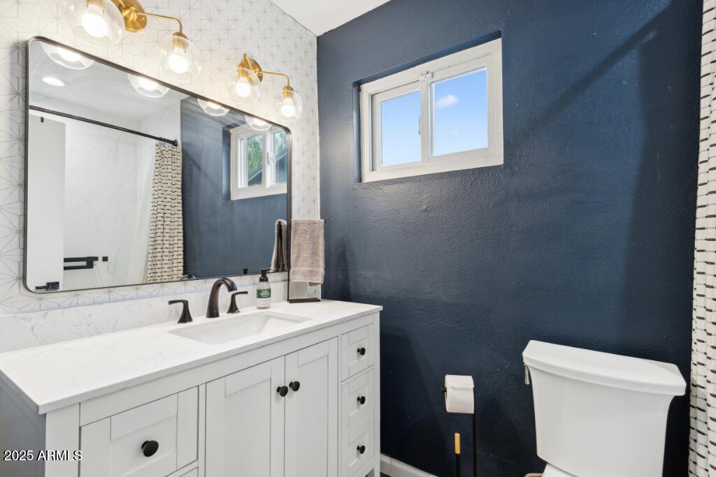 2163 East Sesame Street Tempe, AZ 85283 - Photo 13 of 16 a bathroom with a toilet sink and mirror