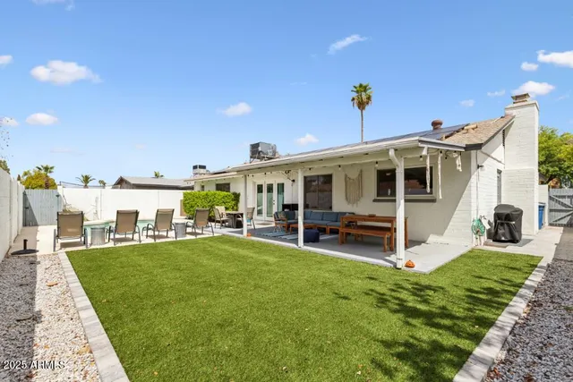 a view of a house with a yard and sitting area