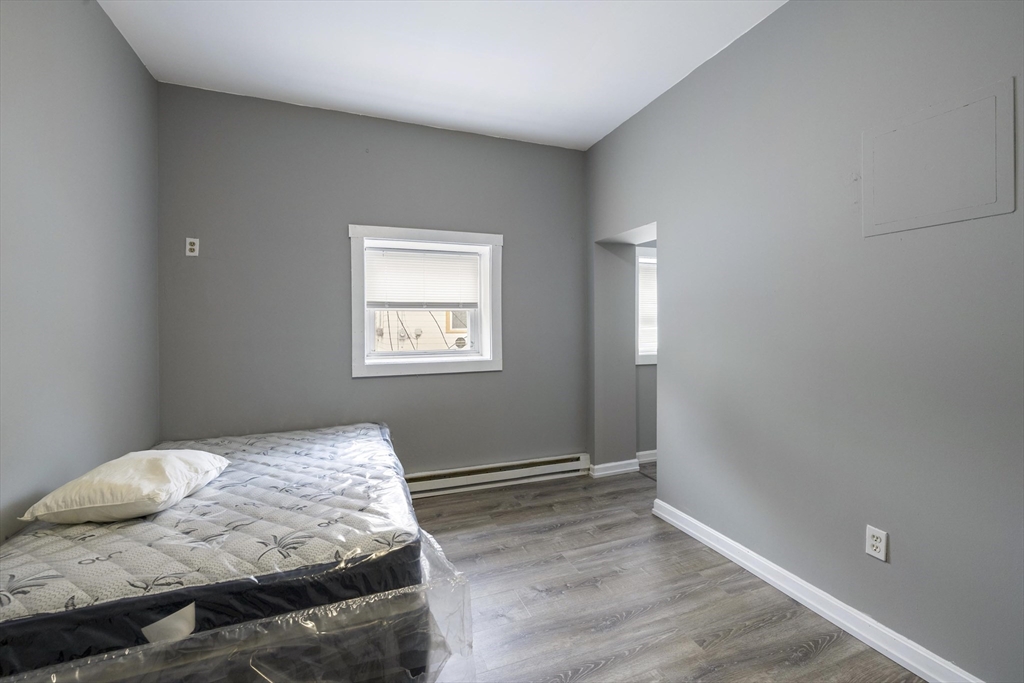 50 East Main Street Orange, MA 01364 - Photo 5 of 23 a bedroom with a bed and wooden floor