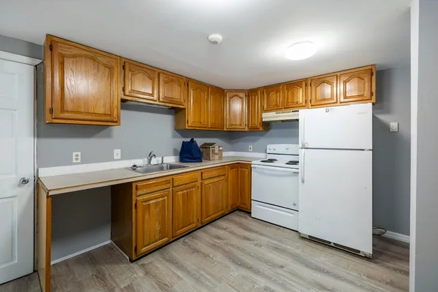 a kitchen with sink cabinets stainless steel appliances and wooden floor
