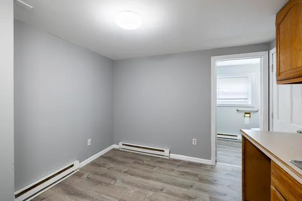 a view of empty room with wooden floor