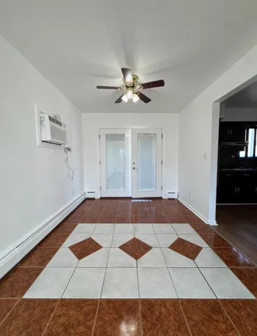 a view of an empty room with window and a chandelier fan