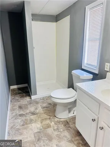 a bathroom with a toilet a sink and a mirror