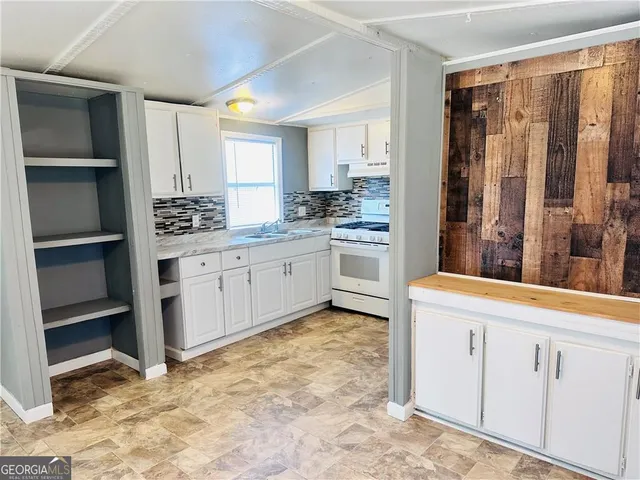 a kitchen with white cabinets and sink