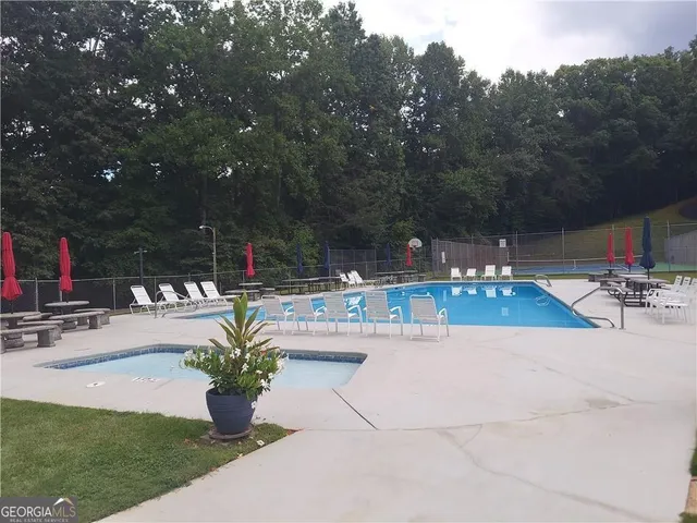 a swimming pool with outdoor seating and garden