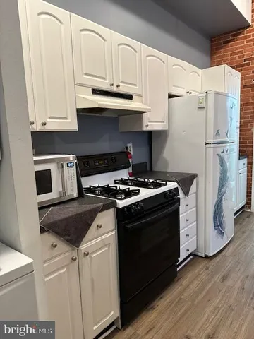 a white stove top oven sitting inside of a kitchen