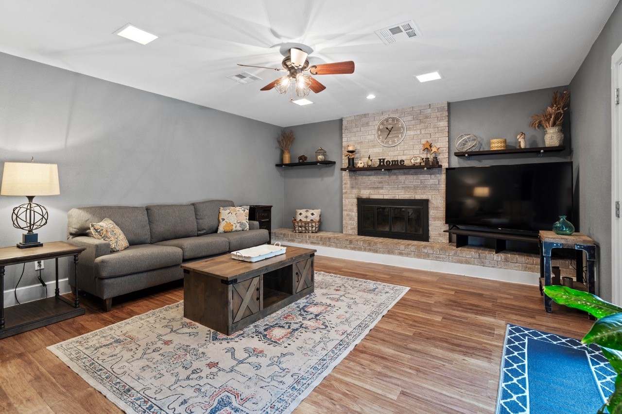 1102 Sherfield Ridge Drive Katy, TX 77450 - Photo 12 of 39 a living room with furniture a flat screen tv and a fireplace