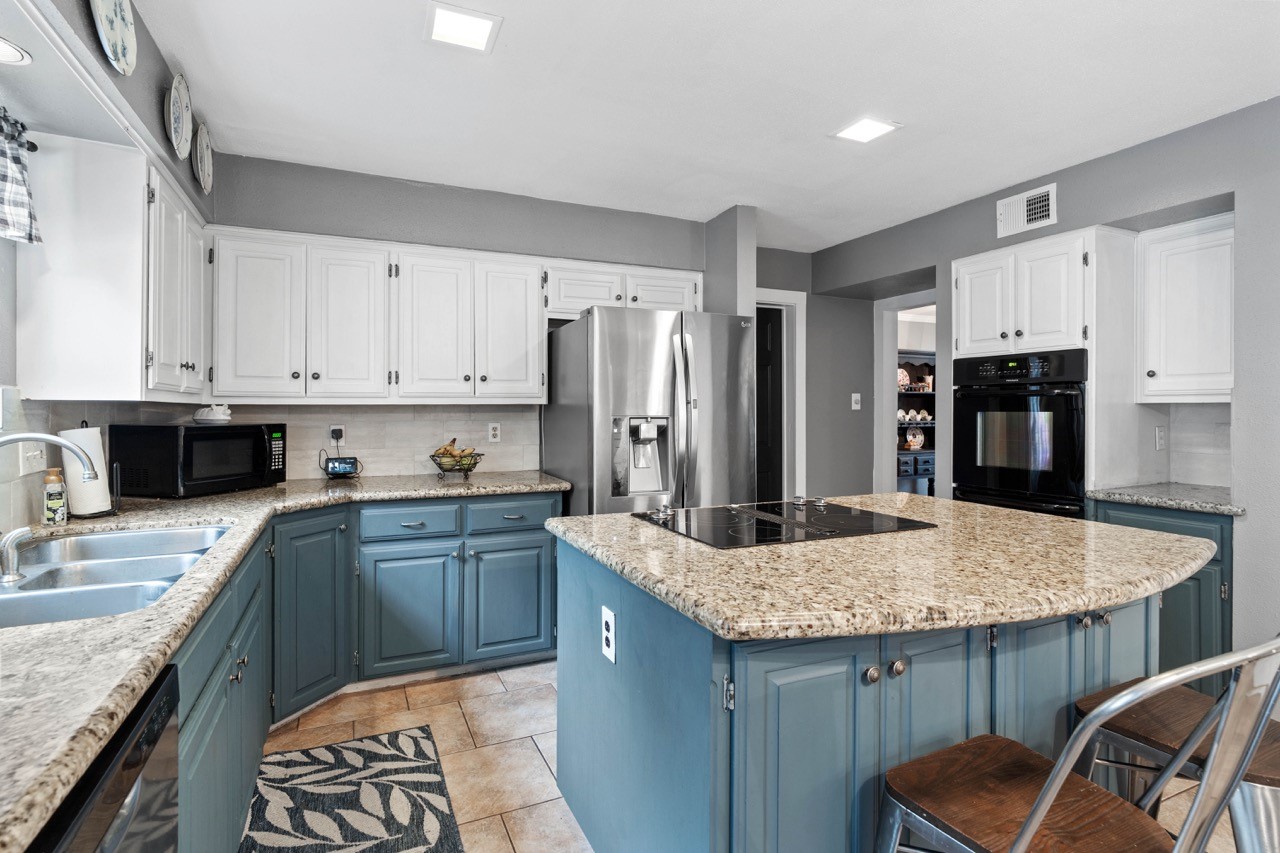 1102 Sherfield Ridge Drive Katy, TX 77450 - Photo 17 of 39 a kitchen with stainless steel appliances granite countertop a sink refrigerator and cabinets