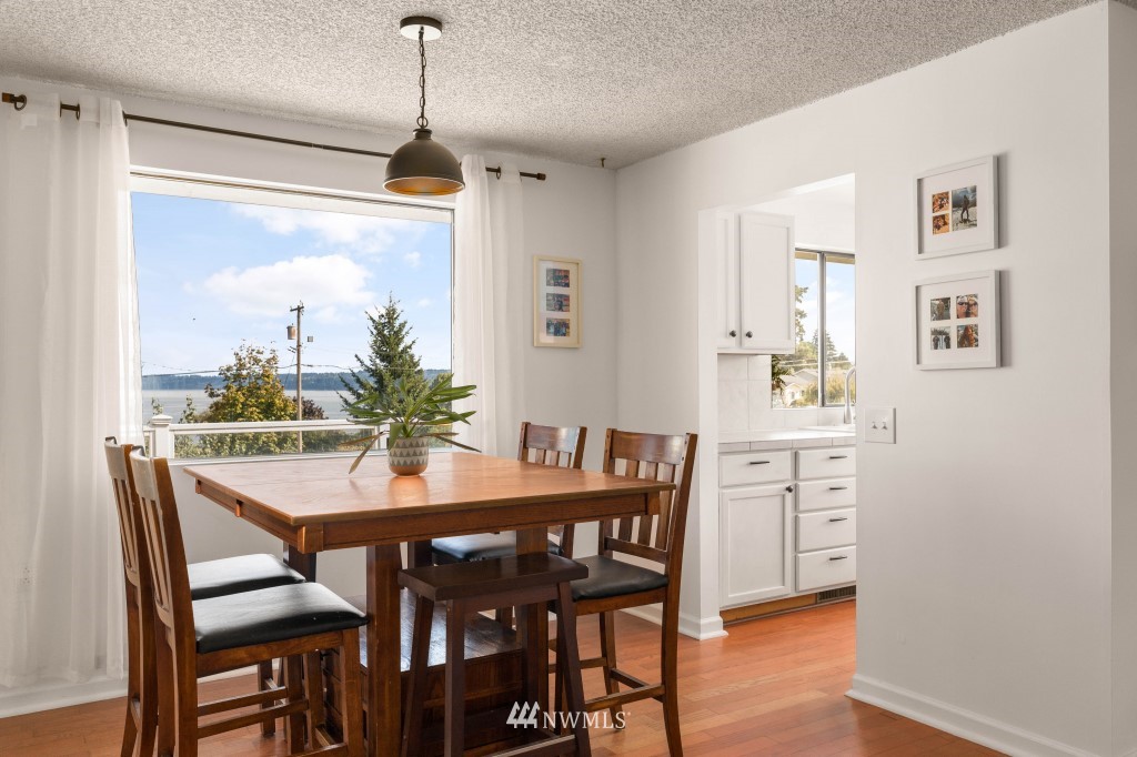 6582 Humphrey Road Clinton, WA 98236 - Photo 13 of 39 a view of a dining room with furniture window and wooden floor