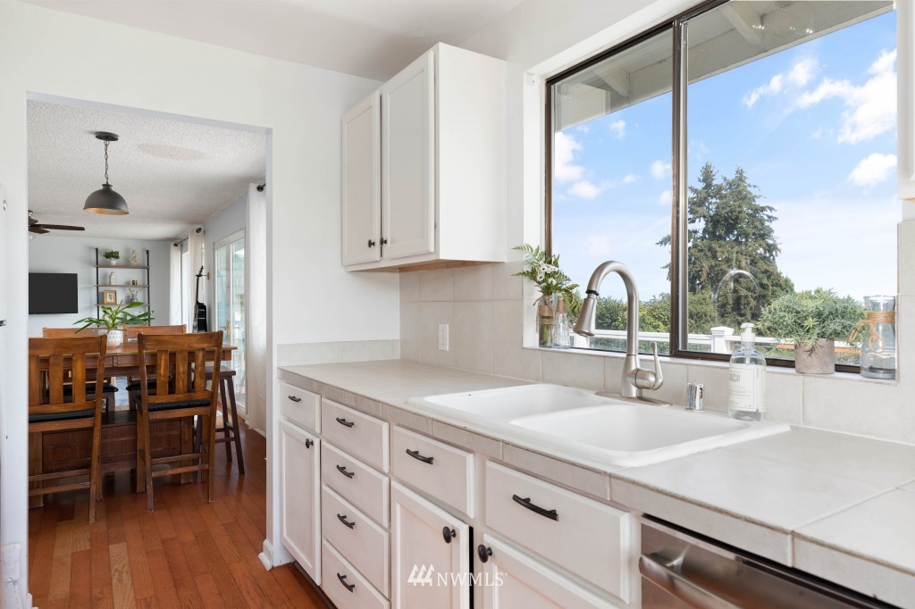 6582 Humphrey Road Clinton, WA 98236 - Photo 17 of 39 a kitchen with stainless steel appliances granite countertop a sink a stove and a refrigerator