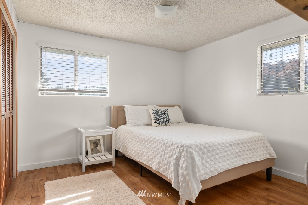 6582 Humphrey Road Clinton, WA 98236 - Photo 21 of 39 a bedroom with a bed and wooden floor