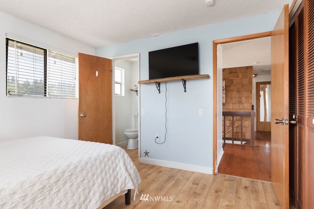 6582 Humphrey Road Clinton, WA 98236 - Photo 22 of 39 a bedroom with a bed and a flat screen tv