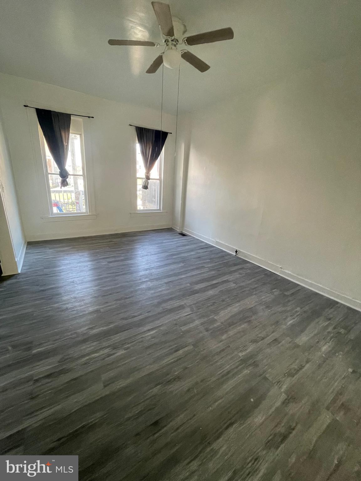 2905 Norfolk Avenue Baltimore, MD 21215 - Photo 9 of 28 an empty room with wooden floor fan and windows