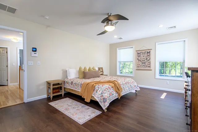 a bedroom with a bed and wooden floor