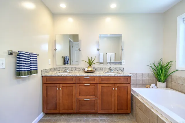 a bathroom with a granite countertop shower a sink and a mirror