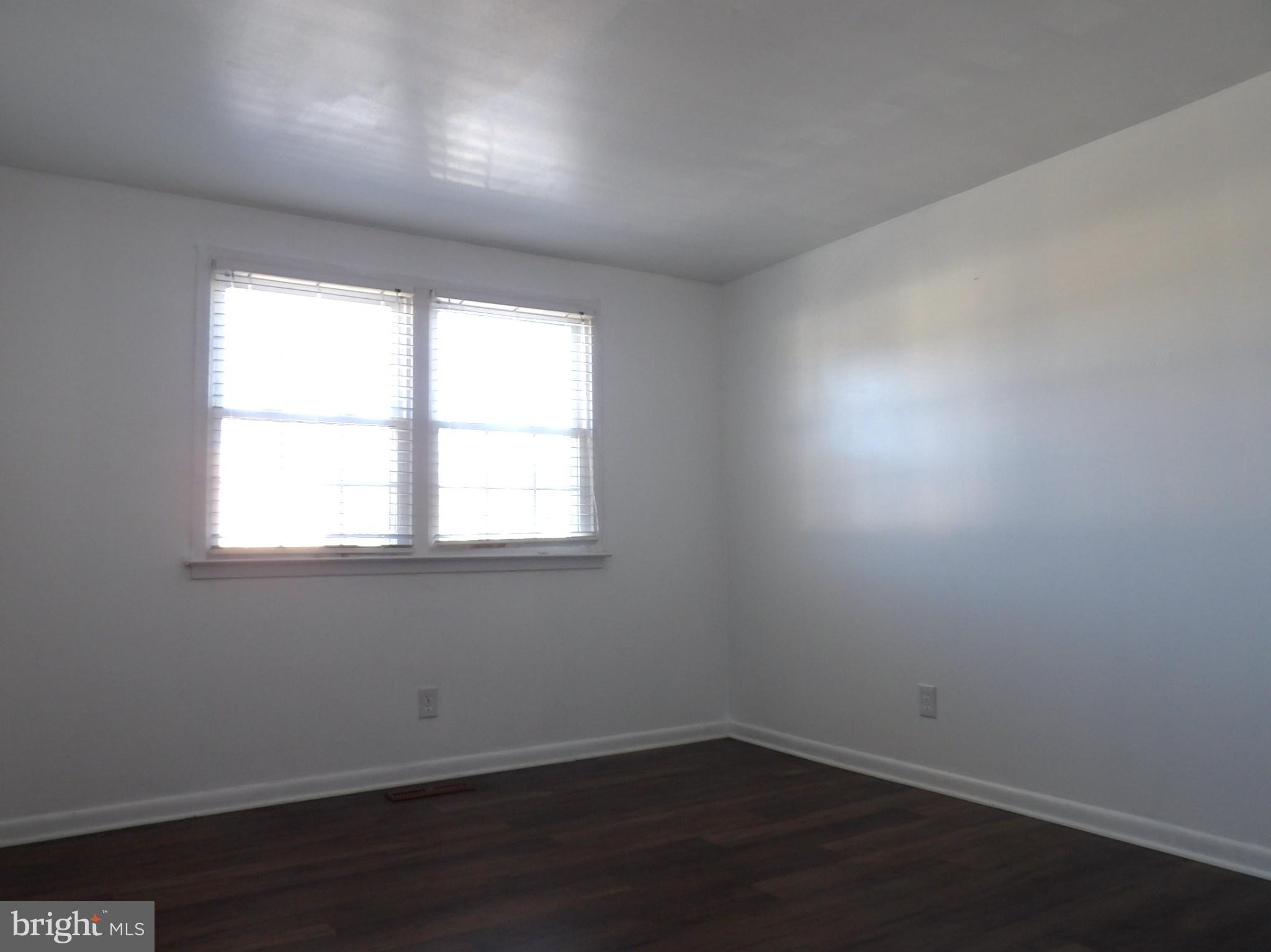 901 Grovehill Road Baltimore, MD 21227 - Photo 20 of 49 an empty room with wooden floor and windows