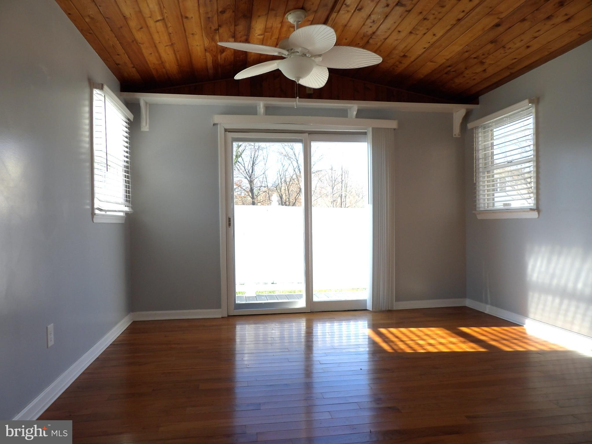 901 Grovehill Road Baltimore, MD 21227 - Photo 38 of 49 a view of empty room with wooden floor and fan