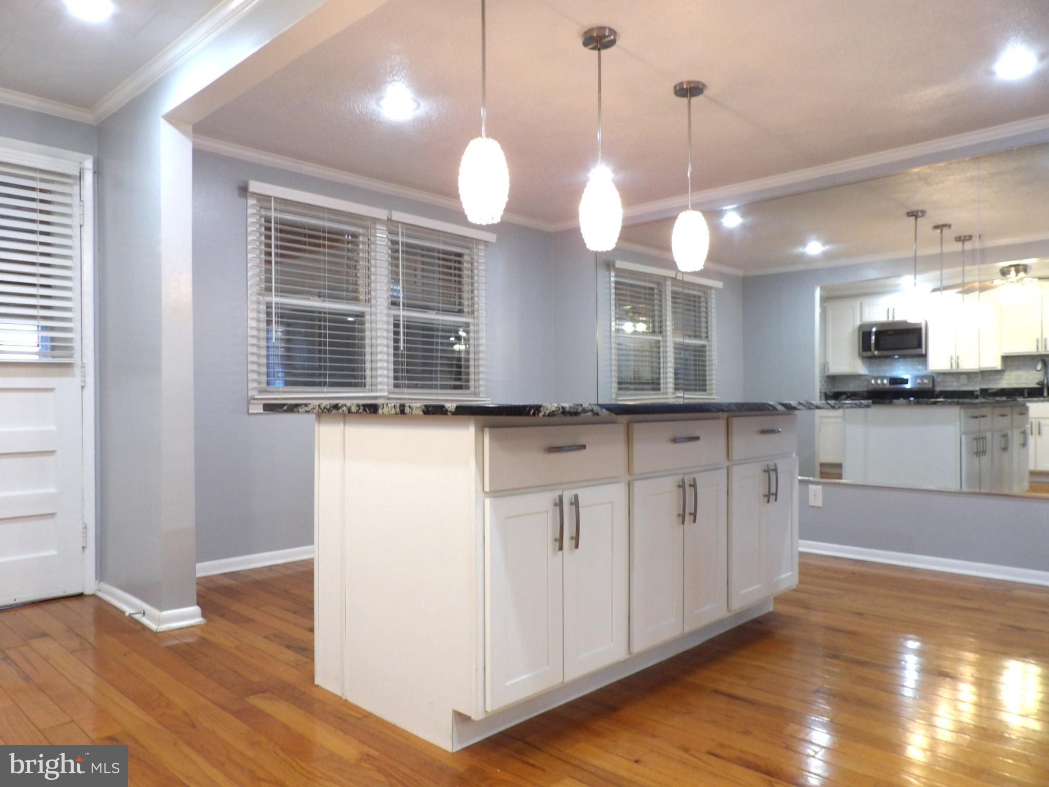 901 Grovehill Road Baltimore, MD 21227 - Photo 7 of 49 a kitchen with a refrigerator a sink and wooden floor