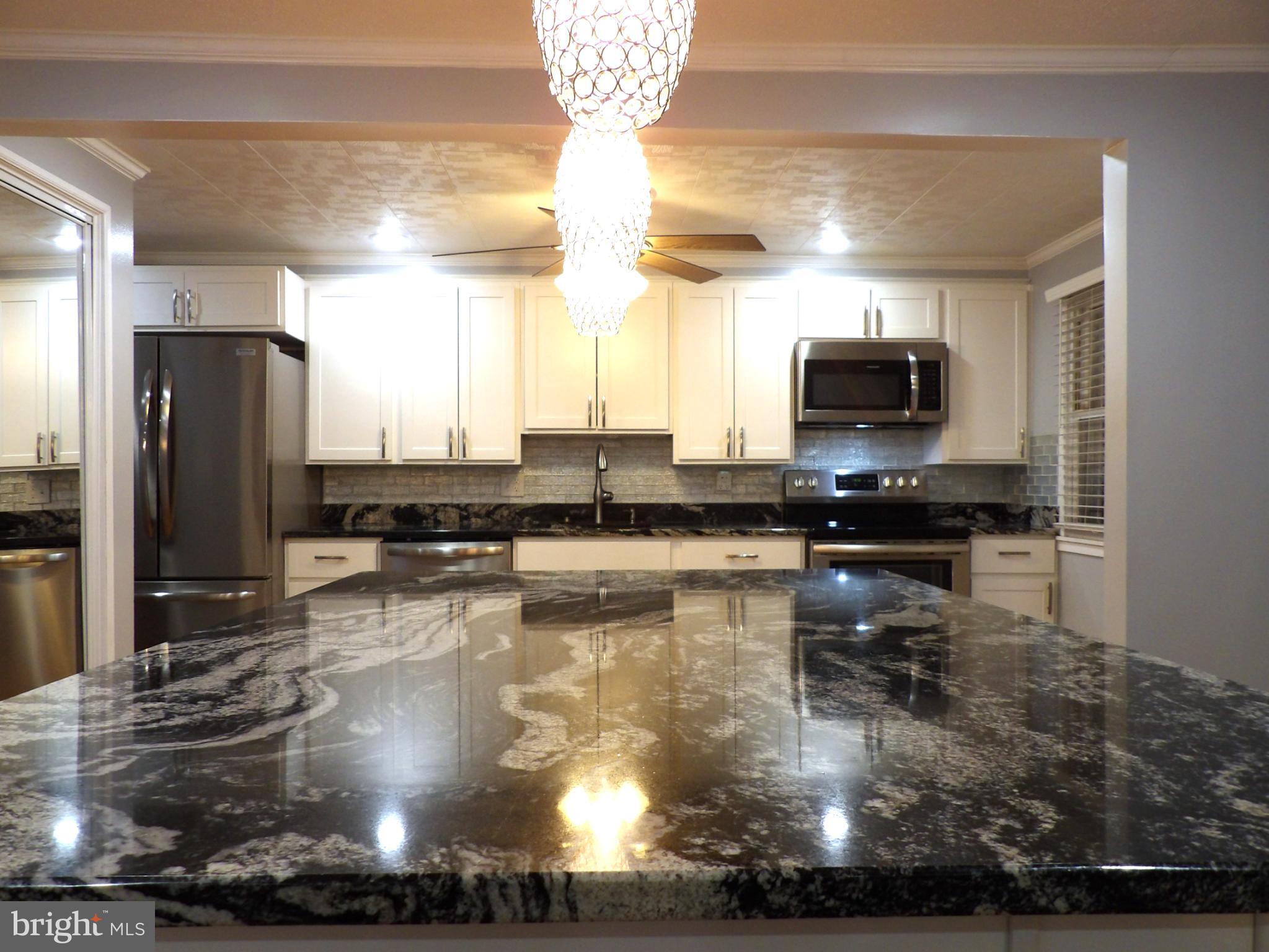 901 Grovehill Road Baltimore, MD 21227 - Photo 8 of 49 a kitchen with stainless steel appliances a sink a stove a microwave a refrigerator and cabinets